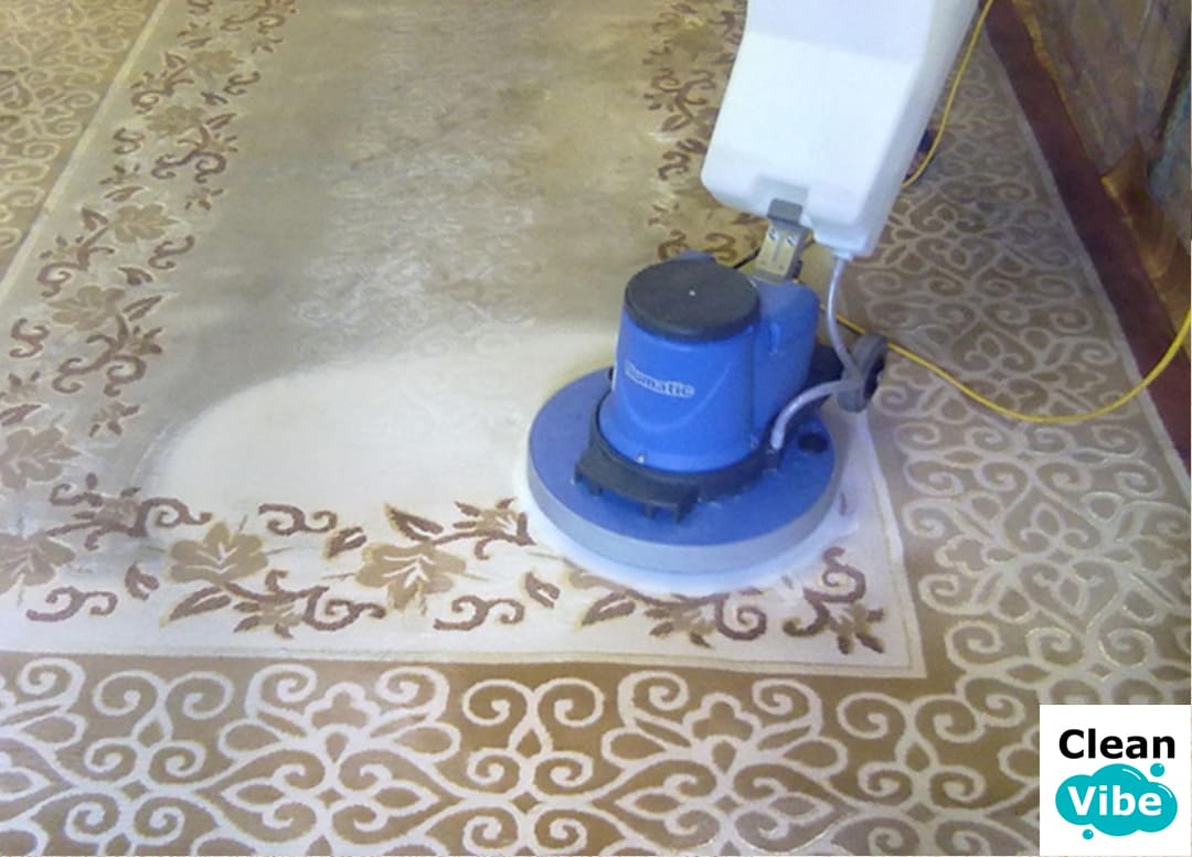 Rotary machine polishing ornate beige area rug