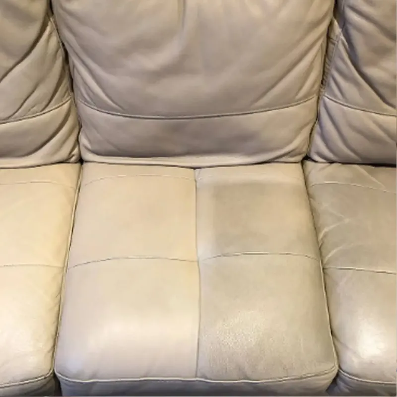 Leather couch being cleaned with microfiber cloth